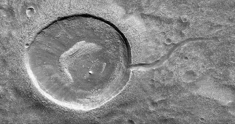 This image from NASA's Mars Reconnaissance Orbiter (MRO) shows an impact crater looking amusingly like a tadpole because of the valley that was carved by water that used to fill it - NASA